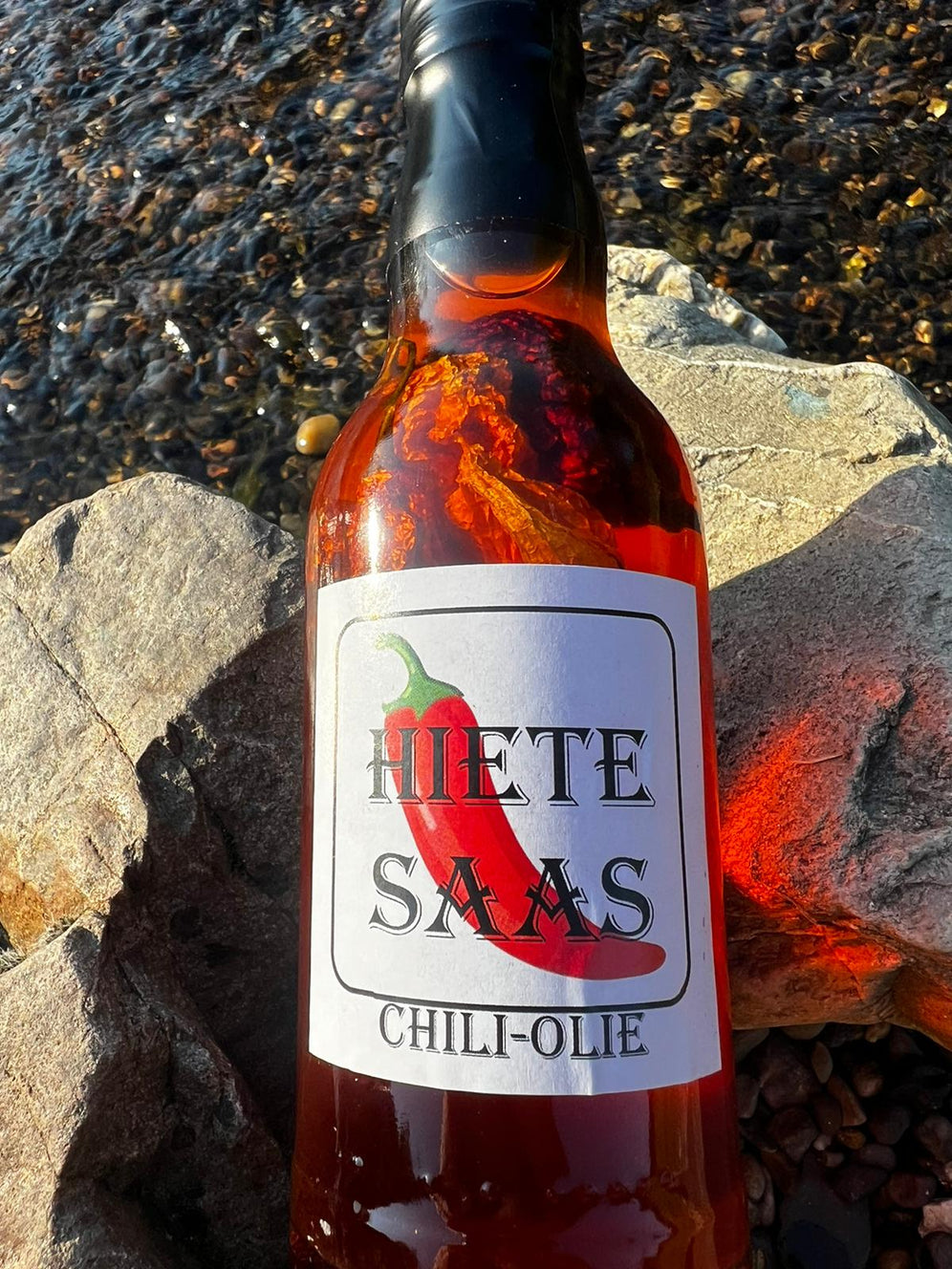 Bouteille de Chili-Olie sauce piquante avec piments bhut jolokai et carolina reaper, idéale pour plats froids et chauds.